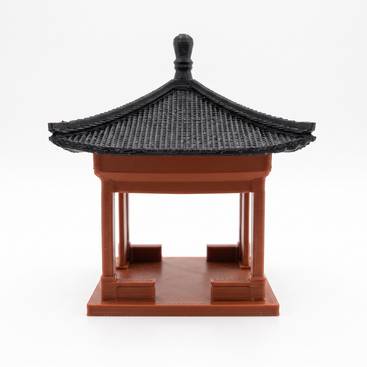 A miniature 3D-printed model of a traditional East Asian pavilion or pagoda with a black tiled roof and reddish-brown wooden structure, shown on a plain white background.